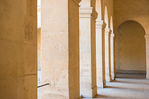 Long empty corridor with arch and stone columns in old building