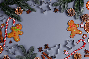 Christmas food frame. Gingerbread cookies, spices and decorations on gray background with copy space