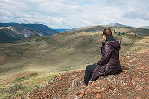 Woman watching to glacier in Altai mountains. Resting in mountains or global warming concept