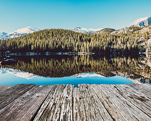 Bear Lake and reflection with mountains in snow around at autumn. Rocky Mountain National Park in Colorado, USA.