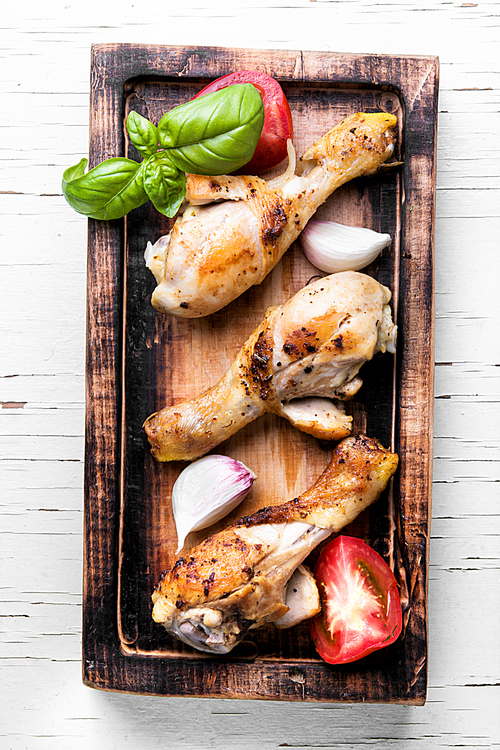 chicken legs on kitchen board in light background