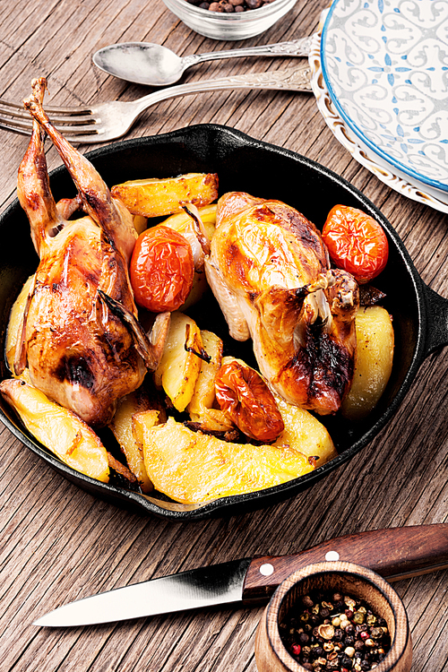 Quail baked with a garnish of potatoes in pan