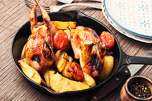 Quail roasted with a garnish of potatoes in pan