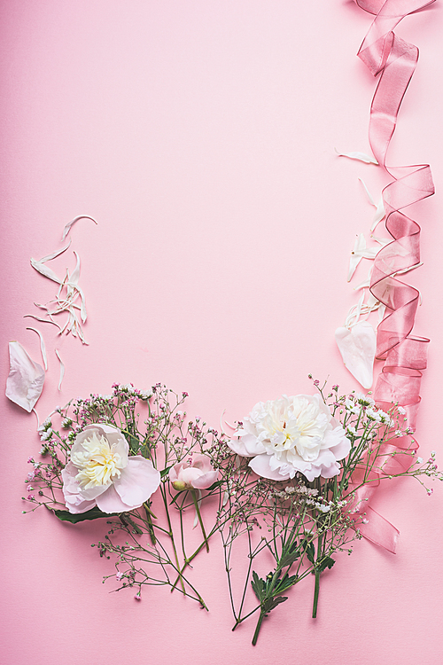Pastel pink floral background with white flowers and ribbon, top view