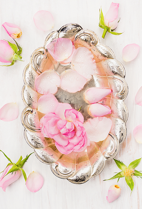 silver bowl with water and roses, top view