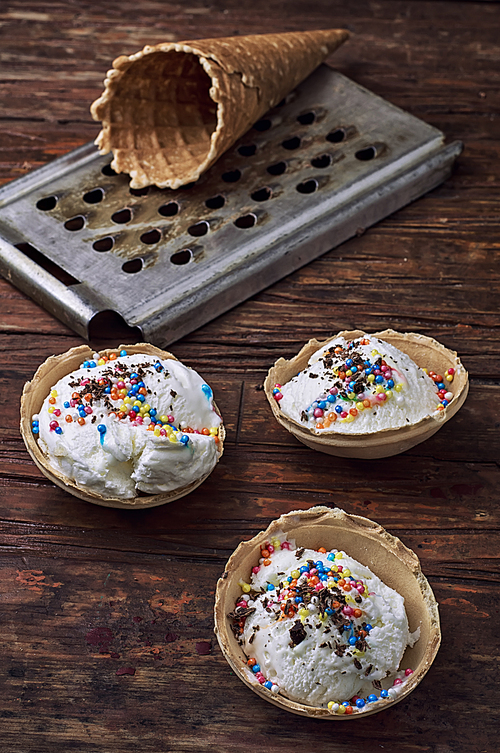 ice cream decorated with sweet powder in the wafer on wooden background