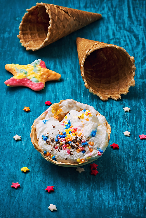 ice cream decorated with sweet powder in the wafer on wooden background