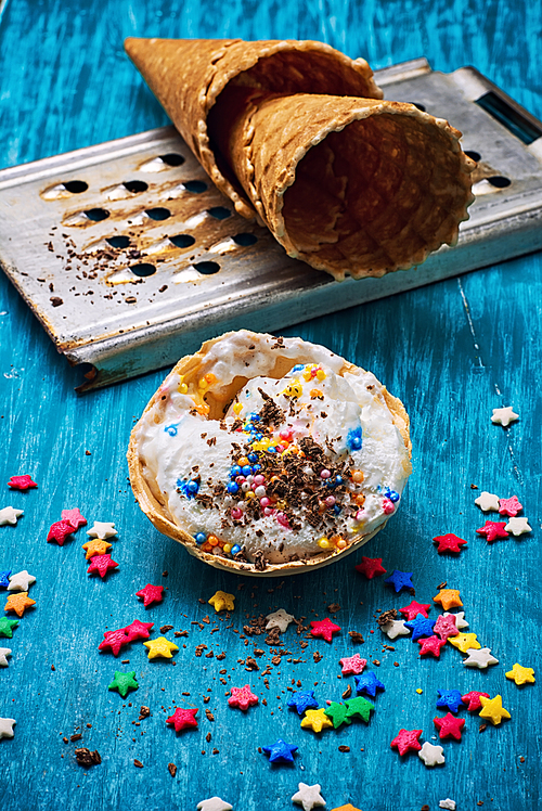 ice cream decorated with sweet powder in the wafer on wooden background