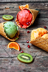 ice-cream cone with kiwi fruit and tangerines on wooden background