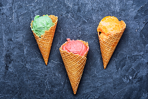 ice-cream waffle cone with fruit on dark slate background