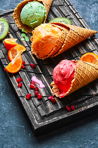 ice-cream waffle cone with fruit on dark slate background