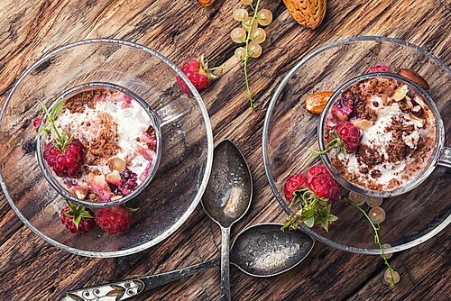 Raspberry ice cream with currants in glass cup.Sundae on vintage rustic background.