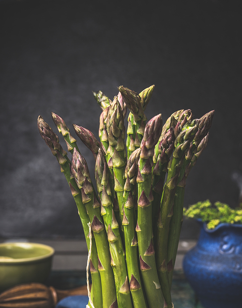 Green asparagus bunch at dark  kitchen background, close up