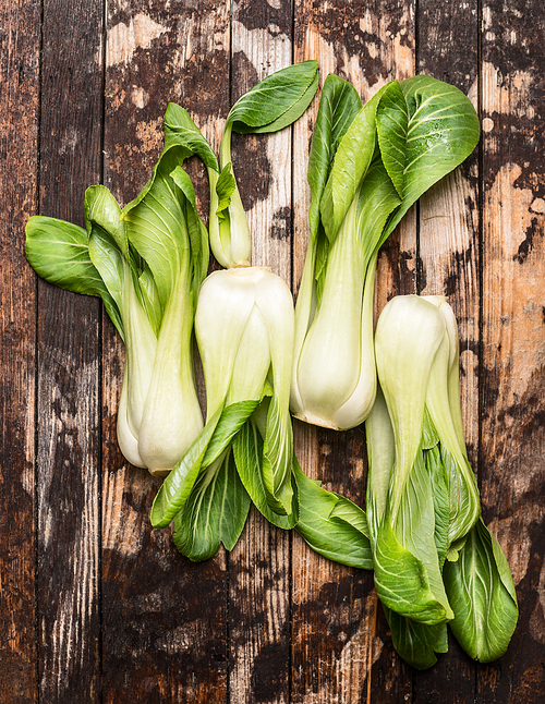 fresh pak choi on rustic wooden background, top view