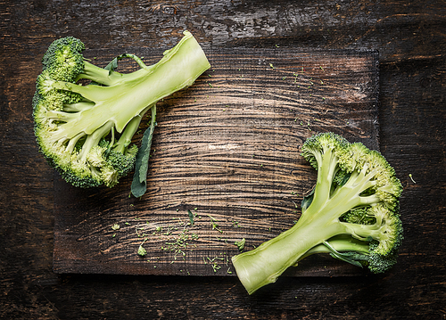 Half of fresh organic  broccoli on dark rustic wooden background, place for text. Vegan or  healthy cooking concept.