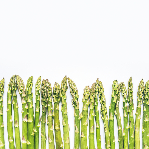 Green asparagus on white background, top view, border , place for text. Healthy  seasonal food