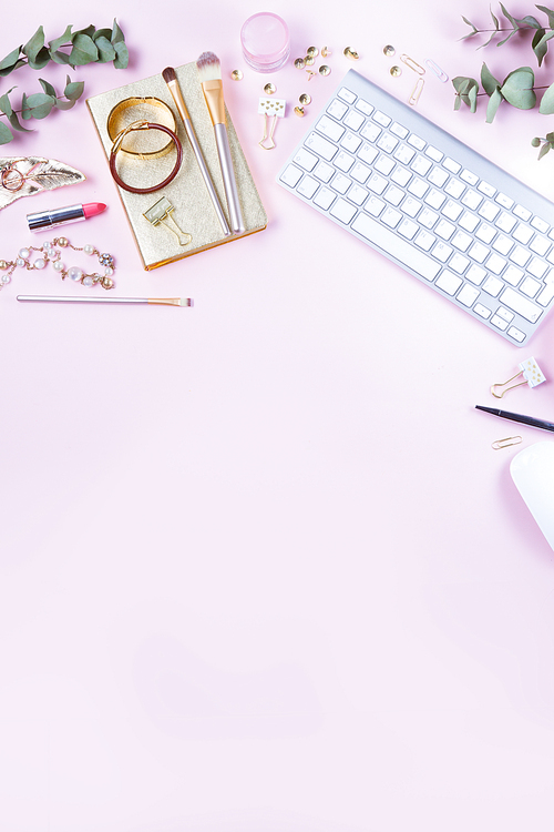 Flat lay home office workspace - white modern keyboard with female accessories, copy space on pink background
