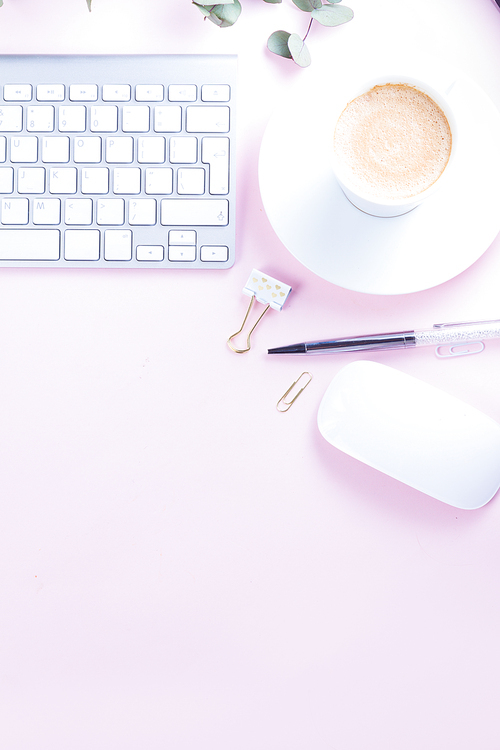 Flat lay home office workspace - white modern keyboard, copy space on pink background