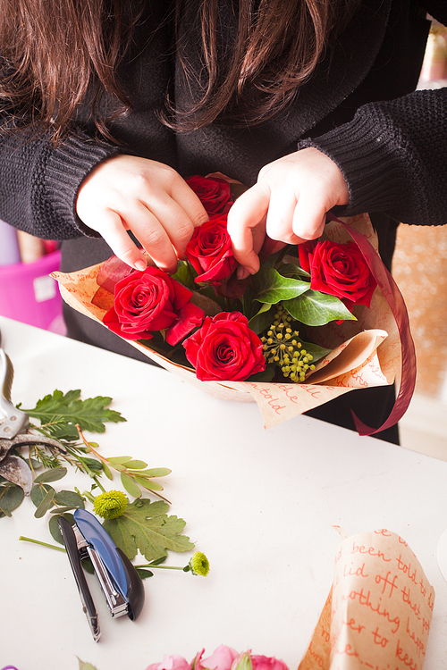 Florist making fashion bouquet of beautiful red roses