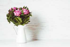 Luxury bouquet of roses lying over wooden wall. Copy space