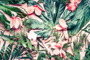 Creative layout made of tropical flowers and palm leaves on pastel pink background, top view,  flat lay