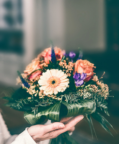 Beautiful flowers bunch with Gerbera and roses in female hand