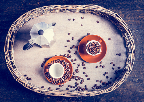 Espresso set with coffee cups, beans and coffee pot on rustic tree and wooden background, top view