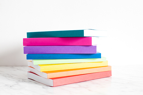 colorful books are outlined in the colors of the . stacked of the books on a shelf near the white wall