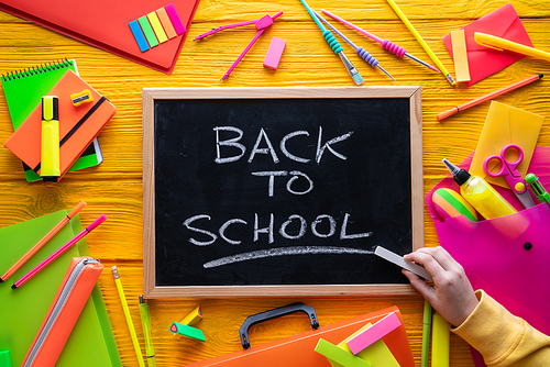 Back to school supplies arrangement vivid colorful neon color and blackboard hand chalk