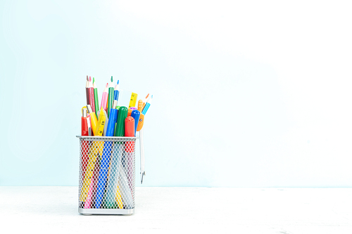 Back to school concept with school supplies on plain blue background with copy space