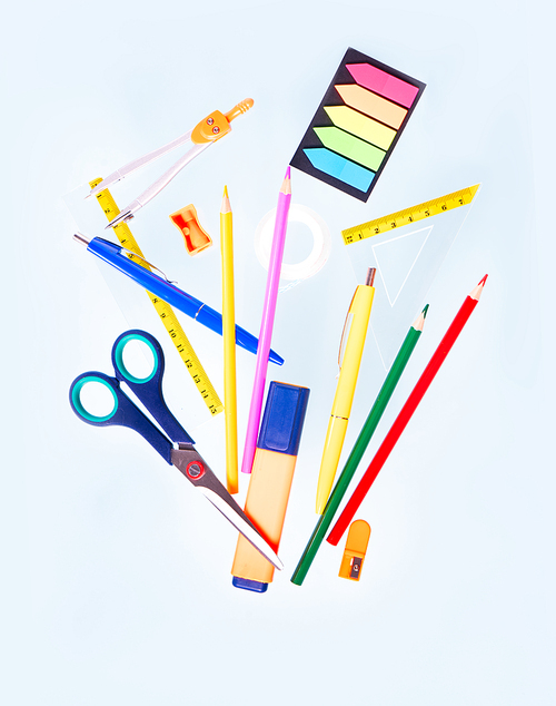 Back to school concept with school supplies falling in can on blue background with copy space
