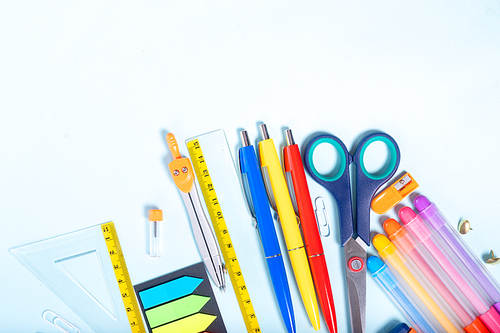 Back to school concept with colorful school supplies border on blue background