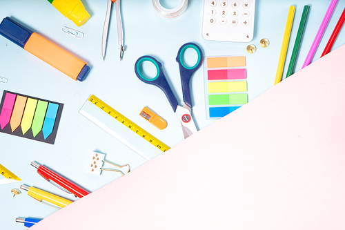 Back to school concept with school supplies on pink and blue background with copy space