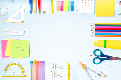 Back to school concept with colorful school supplies on blue background, top view frame with copy space