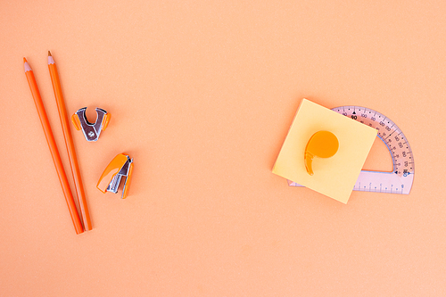 Back to school styled school office supplies on orange background with copy space