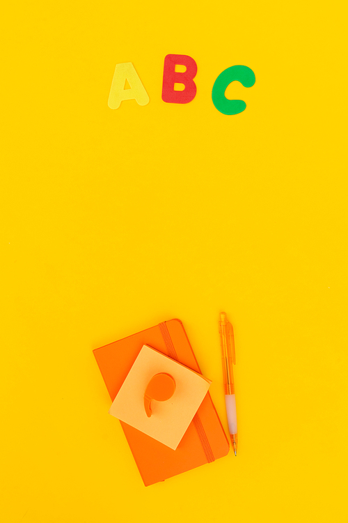 Back to school styled scene with abc and school supplies on yellow background
