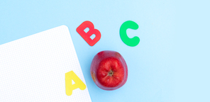 Back to school styled scene with abc letters and apple on blue background