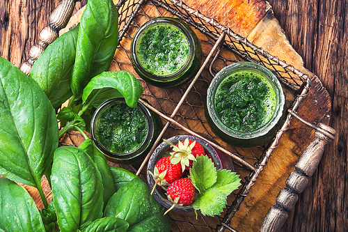 Freshly green smoothie of spinach and strawberry on rustic wood background.Detox