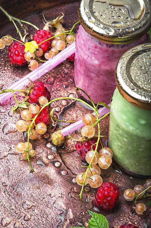 Raspberry yogurt in raspberry and currant berries in a glass jar