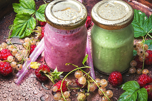 Raspberry yogurt in raspberry and currant berries in a glass jar