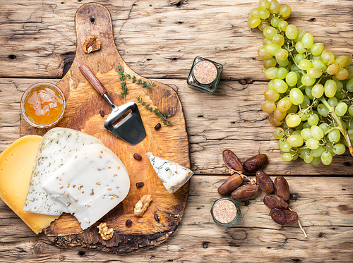Different types of cheese on rustic wooden table