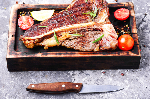 Grilled ribeye beef steak with spices on cutting board