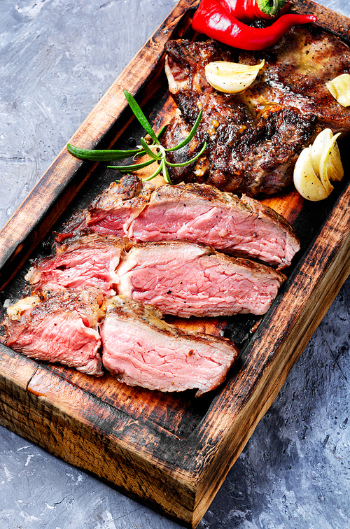 Roasted sliced grill steak on wooden cutting board