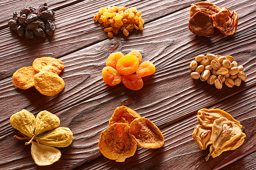 Dried fruits and nuts on vintage rustic wooden background