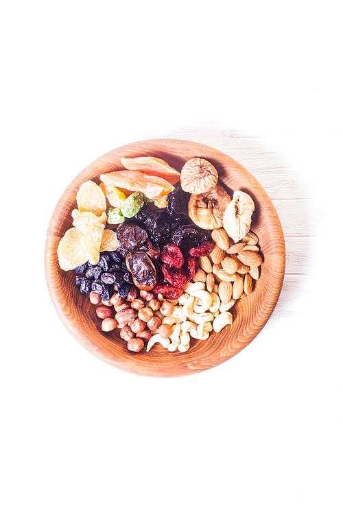 Dry fruits and nuts in bowl on wooden table. Copy space background - close up healthy sweets