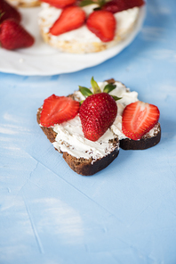 Strawberry sandwiches with mascarpone on blue background
