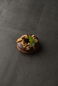 Chocolate Donut with mint leaf on dark stone background