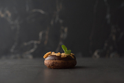 Chocolate Donut with mint leaf on dark stone background