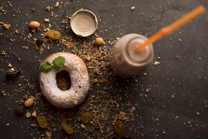 Sugar powder Donut with mint leaf and milk bottle on dark stone background