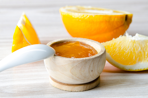 Orange jam served in spoon on the table